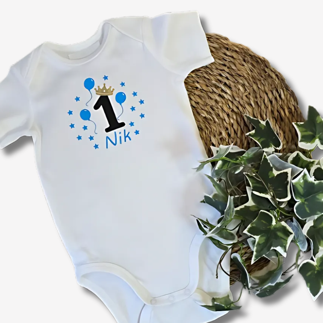 Personaliziran bodi za 1. rojstni dan fantka z veliko številko 1, modrimi baloni, zvezdicami in zlato kronico – ime otroka je mogoče dodati po želji.